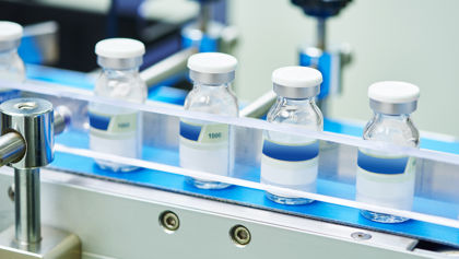 Four vials in a production line at a pharmaceutical factory Four vials in a production line at a pharmaceutical factory