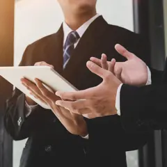 Businesspeople discussing information displayed on a tablet Businesspeople discussing information displayed on a tablet