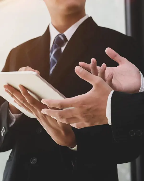 Businesspeople discussing information displayed on a tablet Businesspeople discussing information displayed on a tablet