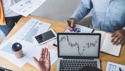 Three people reviewing a financial chart on a computer