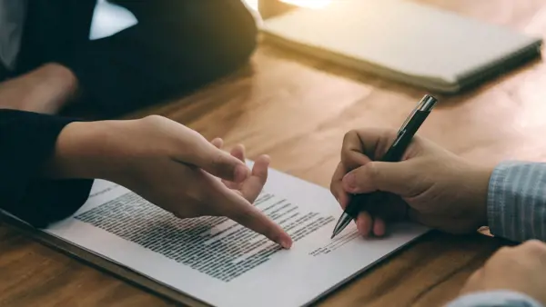 Two hands pointing towards a document Two hands pointing towards a document