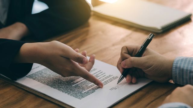 Two hands pointing towards a document