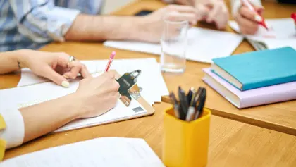 People taking notes at a table People taking notes at a table