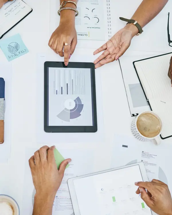 Four people working around a table collaborating on a business value assessment Four people working around a table collaborating on a business value assessment