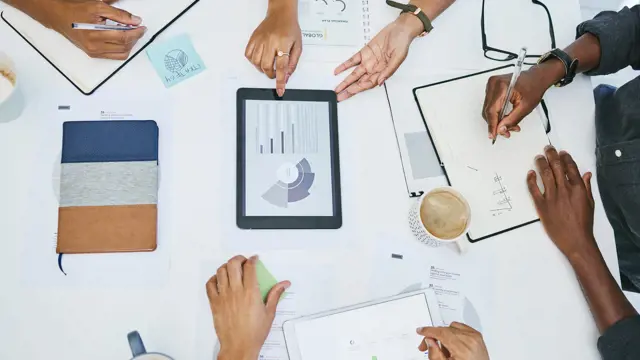 Four people working around a table collaborating on a business value assessment Four people working around a table collaborating on a business value assessment