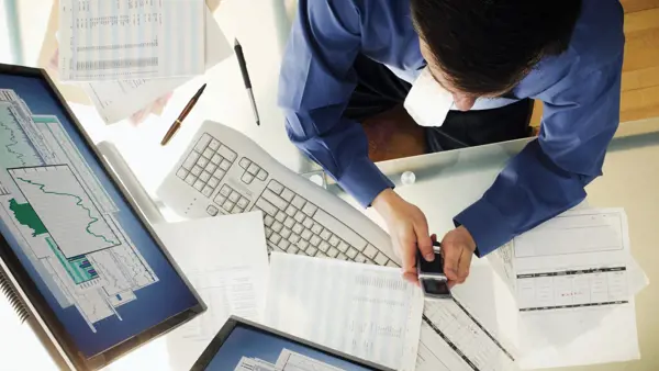 Person working at a desk and using technology Person working at a desk and using technology