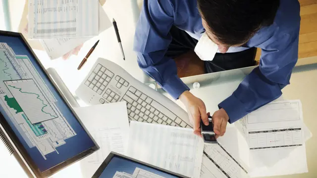 Person working at a desk and using technology Person working at a desk and using technology