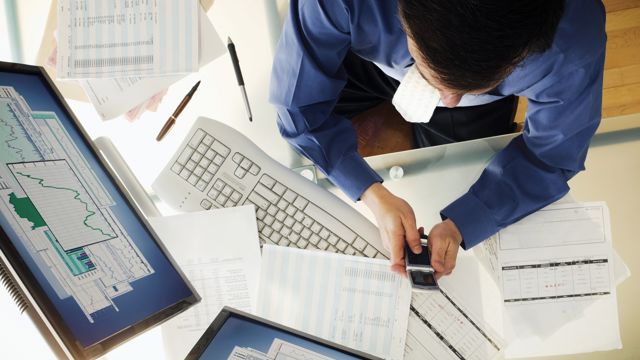 Person working at a desk and using technology