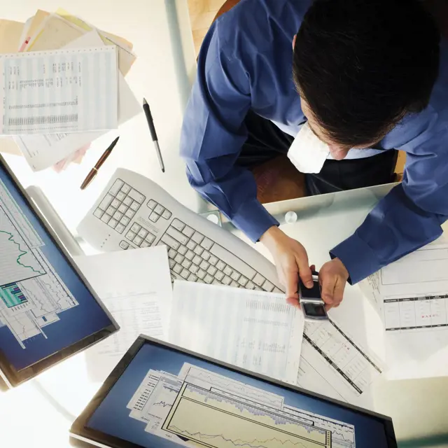 Person working at a desk and using technology Person working at a desk and using technology