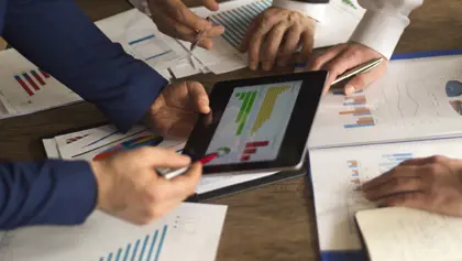 Three people reviewing a financial chart Three people reviewing a financial chart