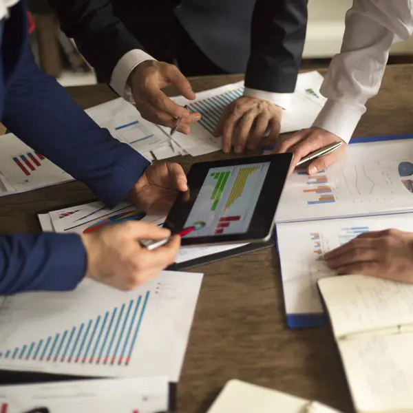 Three people reviewing a financial chart Three people reviewing a financial chart
