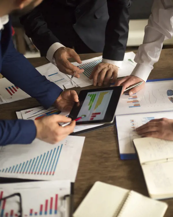 Three people reviewing a financial chart Three people reviewing a financial chart