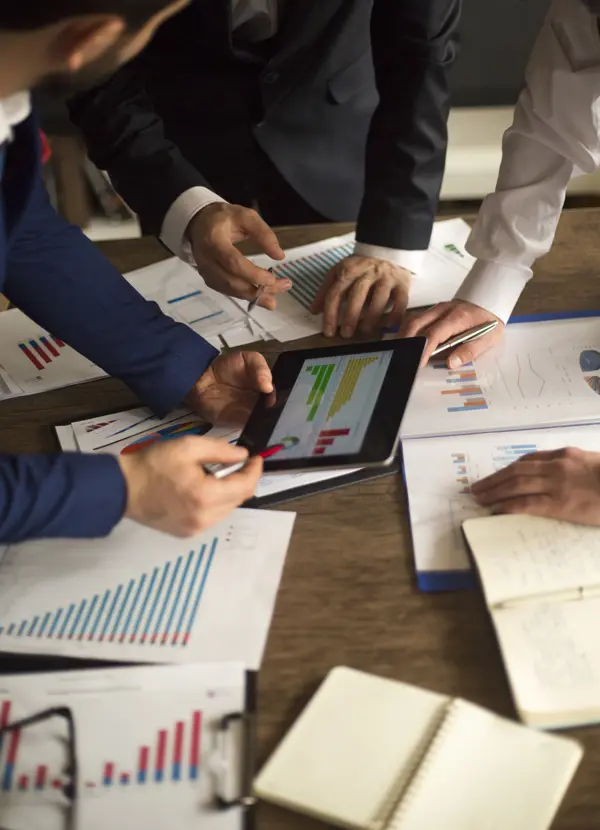 Three people reviewing a financial chart Three people reviewing a financial chart