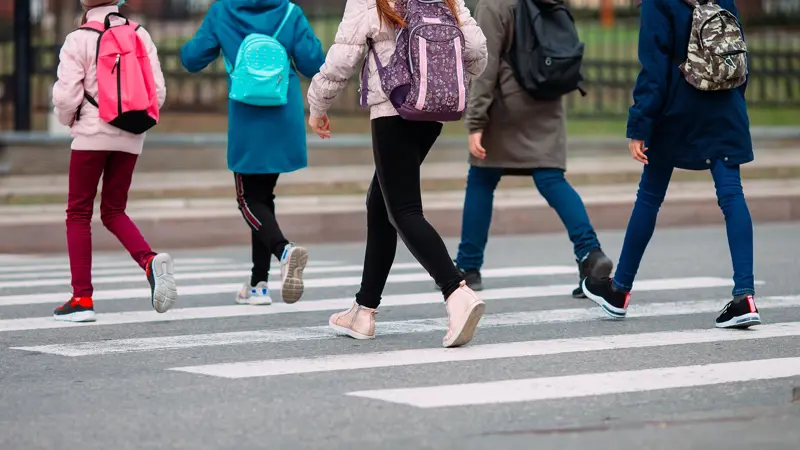 Students walking across the street Students walking across the street