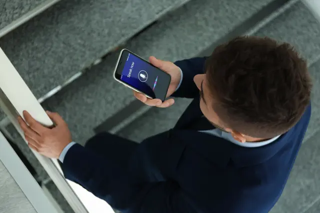 Man using the voice function on his cell phone Man using the voice function on his cell phone